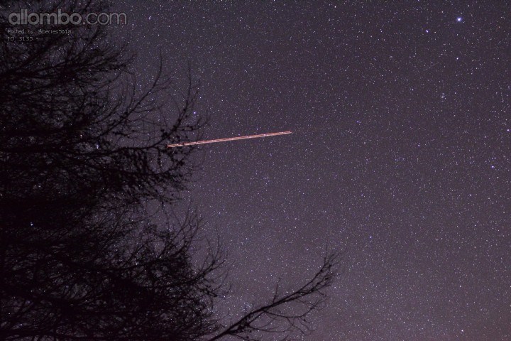 A plane flying across a sky full of stars.