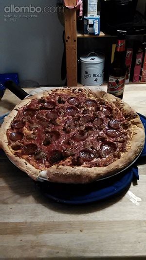 Homemade pizza (sausage, pepperoni, and some onion and green pepper buried ...